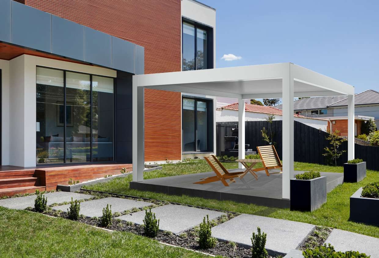 Pérgola blanca de aluminio adosada a una vivienda moderna