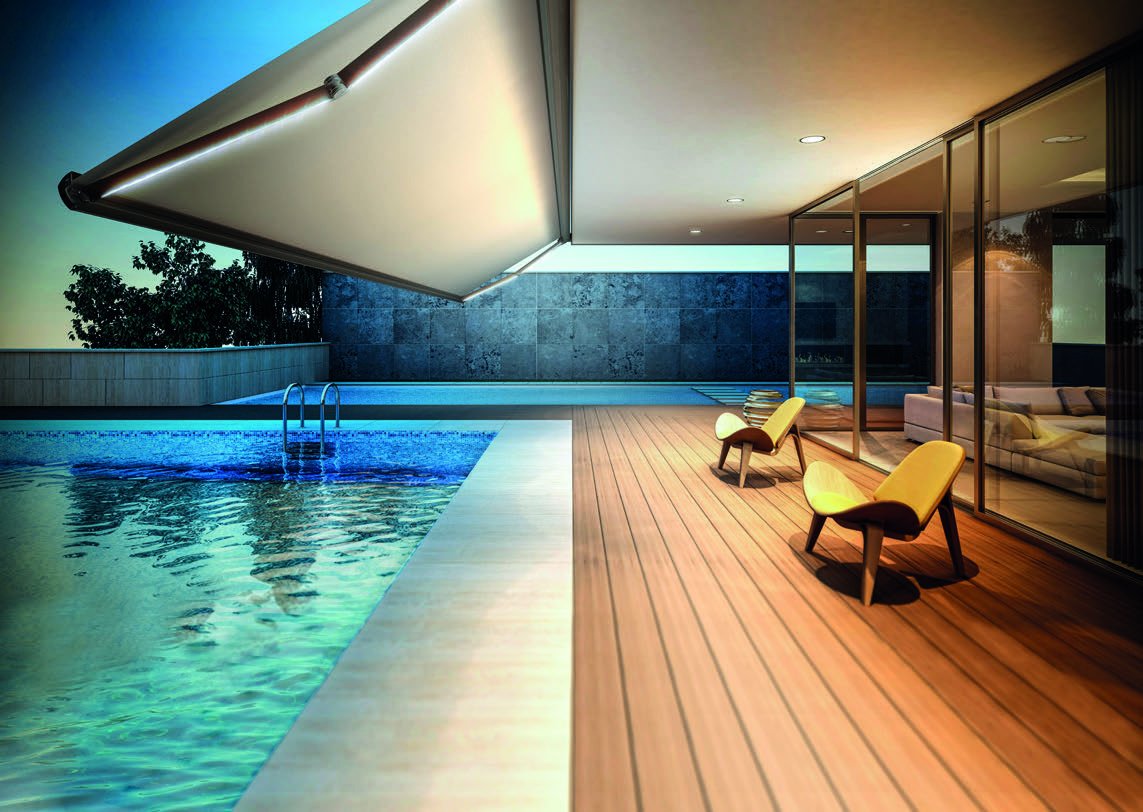 Toldo cofre redondeado abierto sobre una terraza con piscina al atardecer